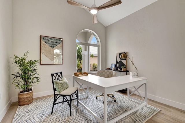 home office with vaulted ceiling, light hardwood / wood-style floors, and ceiling fan