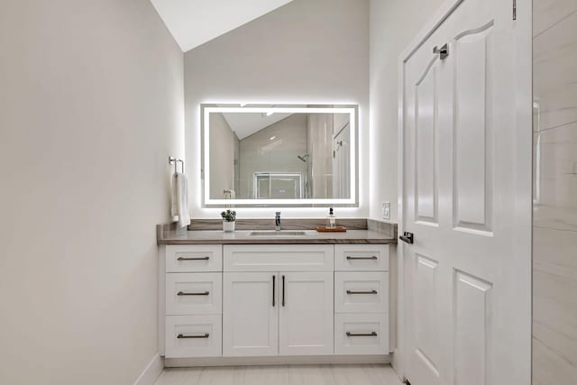 bathroom with vanity, an enclosed shower, and vaulted ceiling