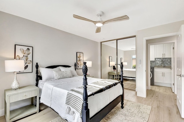 bedroom with sink, light hardwood / wood-style floors, a closet, and ceiling fan