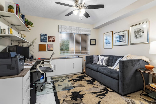 office space with ceiling fan, a textured ceiling, and light tile patterned flooring