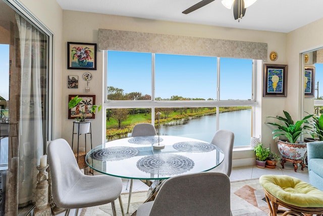 sunroom / solarium with a water view and ceiling fan