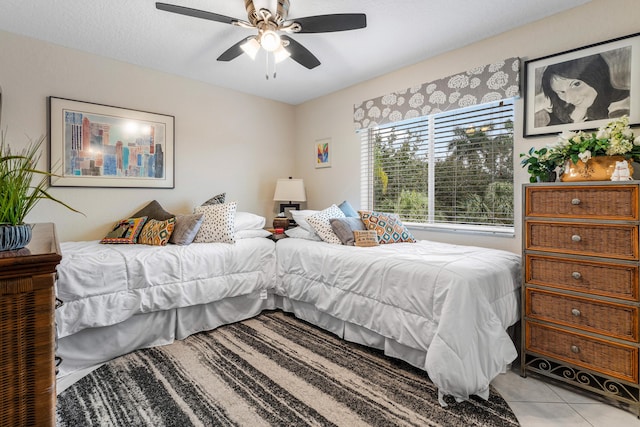 tiled bedroom featuring ceiling fan and a textured ceiling