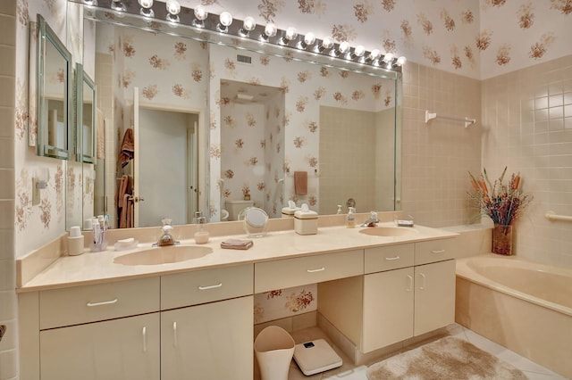 bathroom with a washtub, tile patterned floors, and vanity