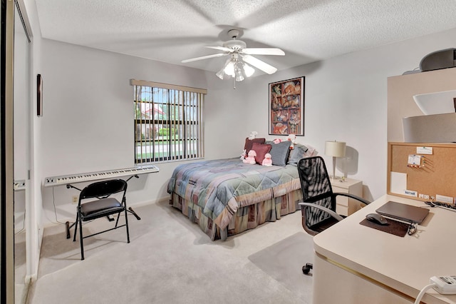 carpeted bedroom with ceiling fan and a textured ceiling