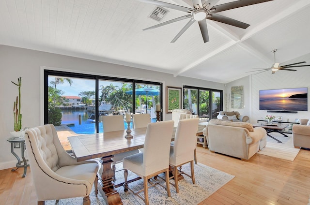 dining room featuring a water view, plenty of natural light, and light wood-type flooring