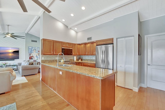 kitchen featuring light hardwood / wood-style flooring, sink, stainless steel fridge, and kitchen peninsula