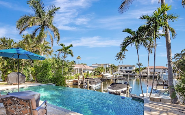 view of swimming pool featuring a water view, area for grilling, and a boat dock