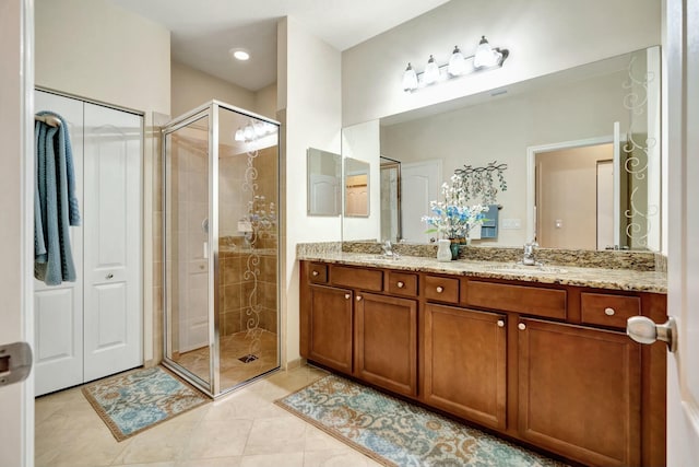 bathroom featuring vanity, a shower with door, and tile patterned flooring