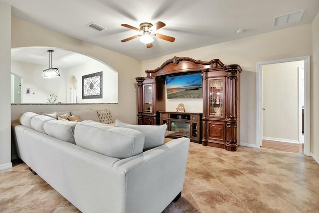 living room featuring ceiling fan and a fireplace