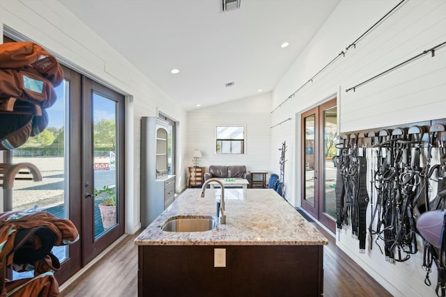 kitchen with a kitchen island with sink, sink, dark hardwood / wood-style floors, and french doors