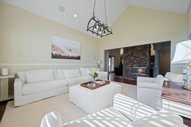 living room with hardwood / wood-style floors, a fireplace, high vaulted ceiling, and a chandelier