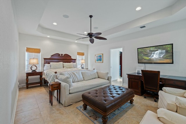 bedroom with a raised ceiling and ceiling fan