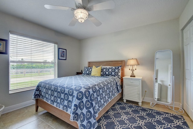 tiled bedroom featuring ceiling fan