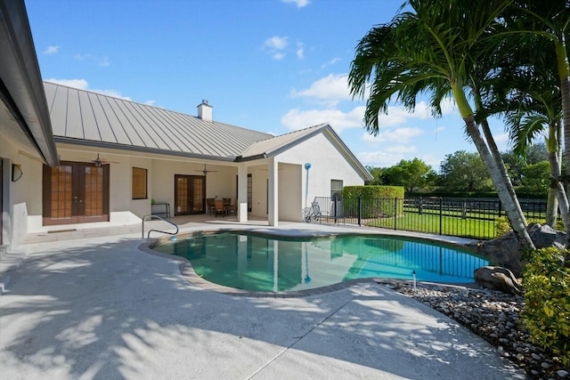 view of pool with french doors, ceiling fan, and a patio