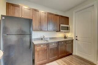 kitchen with black refrigerator, sink, and light hardwood / wood-style floors