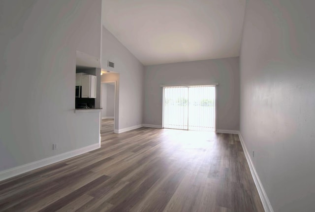 unfurnished living room with high vaulted ceiling and dark hardwood / wood-style floors