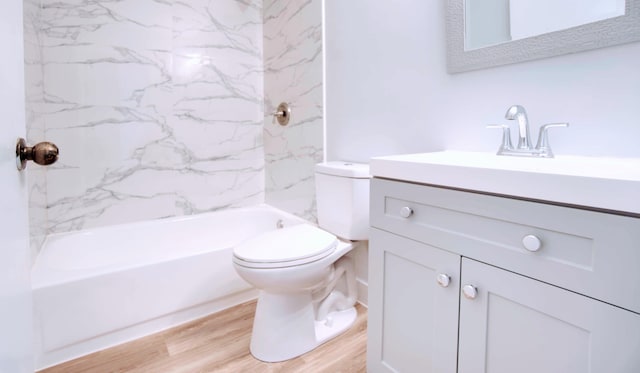 full bathroom with vanity, hardwood / wood-style flooring, tiled shower / bath combo, and toilet