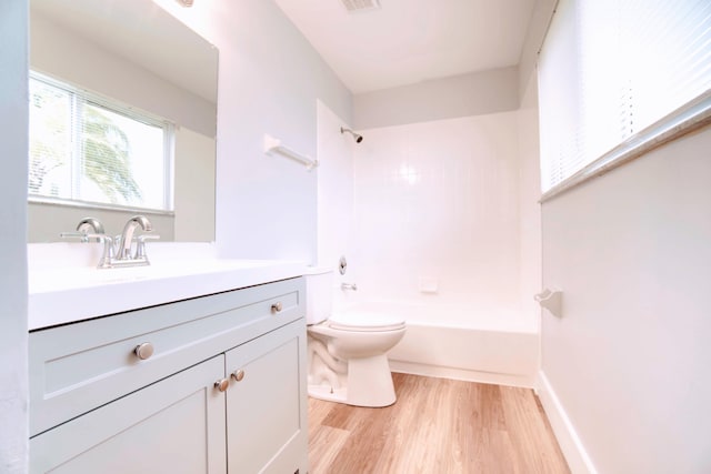 full bathroom with hardwood / wood-style flooring, toilet, vanity, and tiled shower / bath