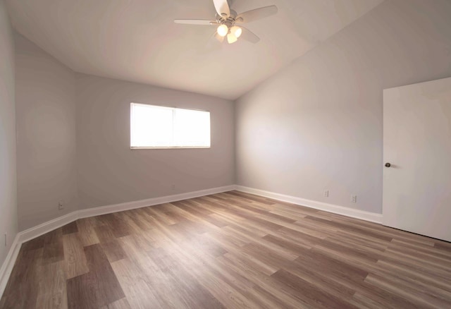 empty room with hardwood / wood-style flooring, lofted ceiling, and ceiling fan