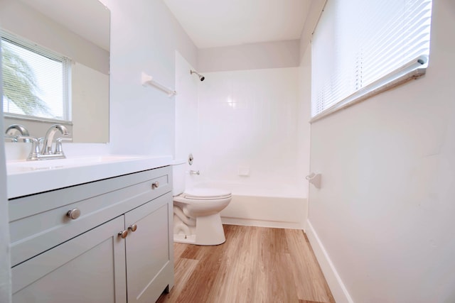 full bathroom with hardwood / wood-style flooring, toilet, vanity, and shower / washtub combination