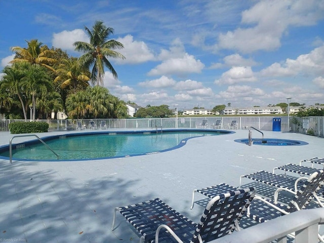 view of swimming pool featuring a hot tub