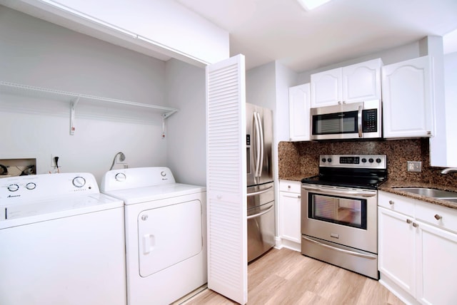 laundry room with sink, light hardwood / wood-style flooring, and washer and dryer