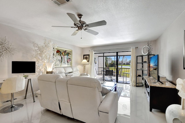 living room featuring ceiling fan and a textured ceiling