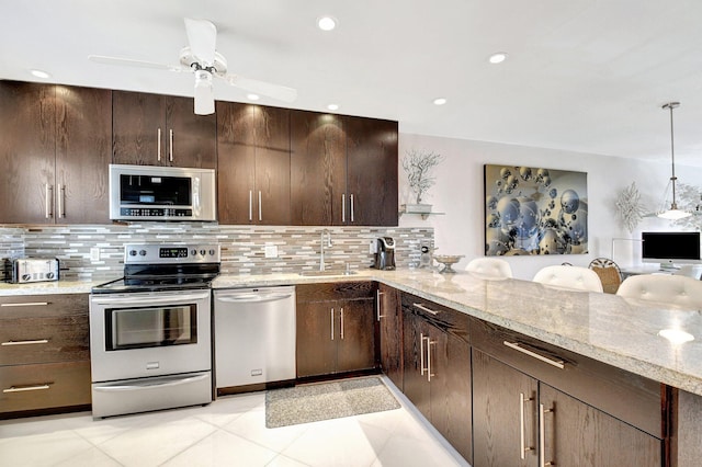 kitchen with tasteful backsplash, stainless steel appliances, sink, and pendant lighting