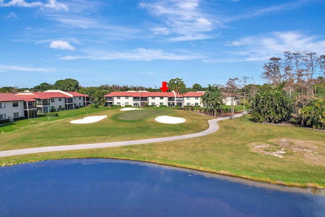 view of property's community with a water view and a lawn