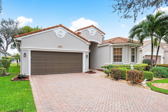 mediterranean / spanish-style house with a garage and a front yard