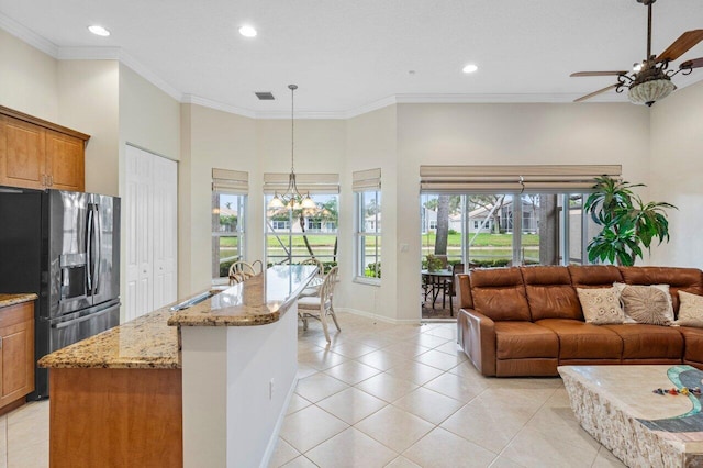 living room featuring sink, ceiling fan with notable chandelier, crown molding, and light tile patterned floors