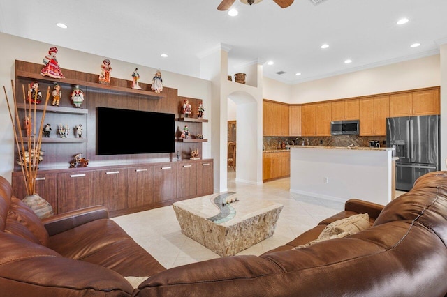 living room featuring ceiling fan, ornamental molding, and light tile patterned flooring