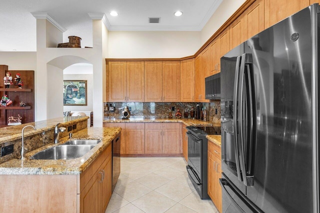 kitchen featuring black appliances, crown molding, light stone countertops, and sink