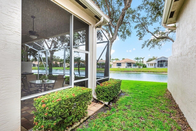 view of yard with a water view and a lanai