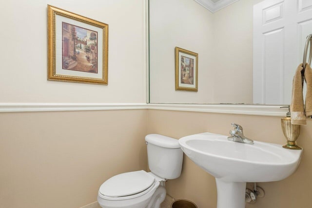 bathroom featuring sink, toilet, and ornamental molding