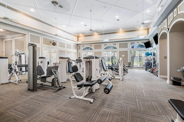 exercise room with carpet floors and a high ceiling