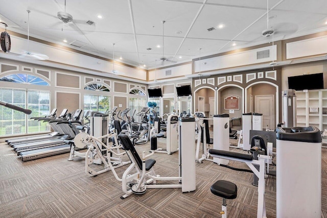 exercise room featuring a towering ceiling, ceiling fan, and carpet floors