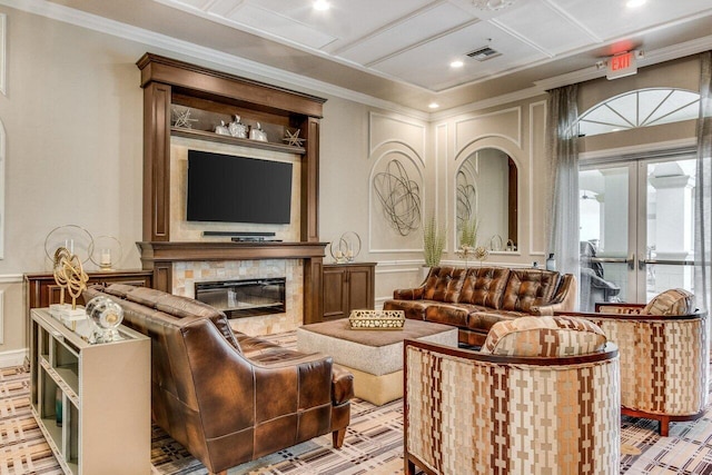 interior space featuring crown molding, a tiled fireplace, and french doors