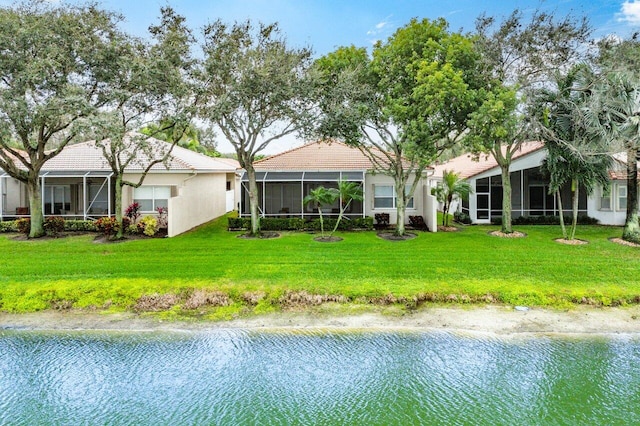 rear view of property featuring a lawn and a water view