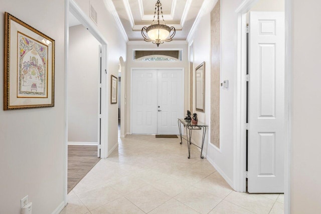 corridor featuring light tile patterned floors, a tray ceiling, and crown molding