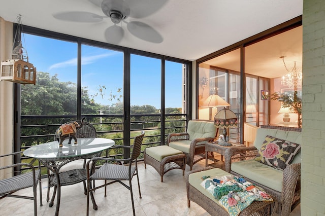 sunroom with ceiling fan with notable chandelier and a wealth of natural light