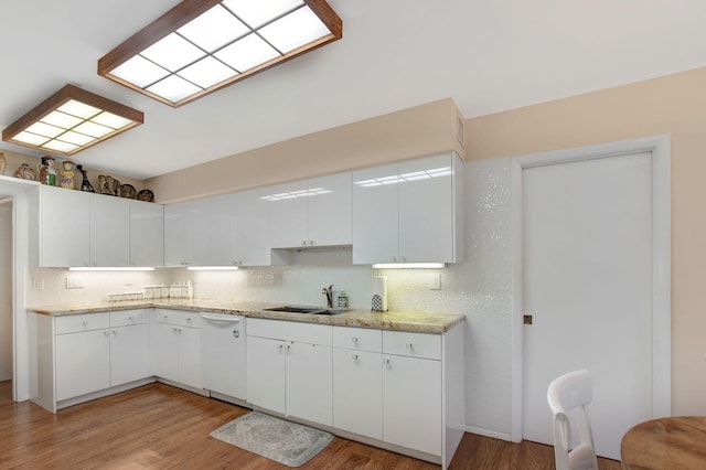 kitchen with sink, tasteful backsplash, light wood-type flooring, white dishwasher, and white cabinets