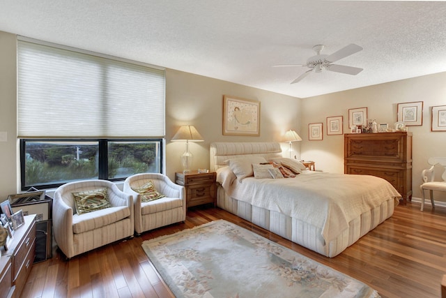 bedroom featuring ceiling fan, dark hardwood / wood-style floors, and a textured ceiling