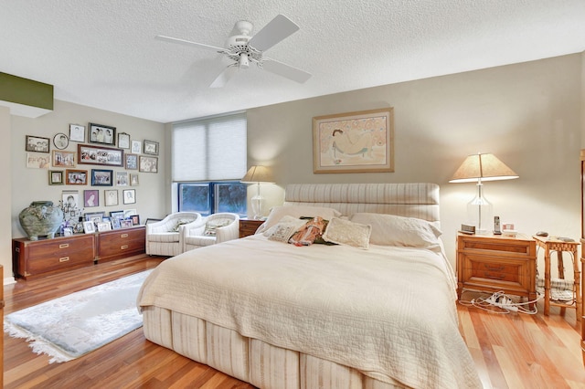 bedroom with hardwood / wood-style floors, a textured ceiling, and ceiling fan