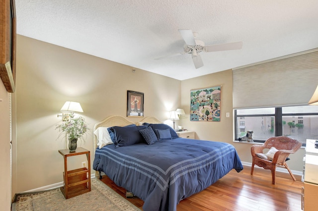 bedroom featuring hardwood / wood-style flooring, ceiling fan, and a textured ceiling