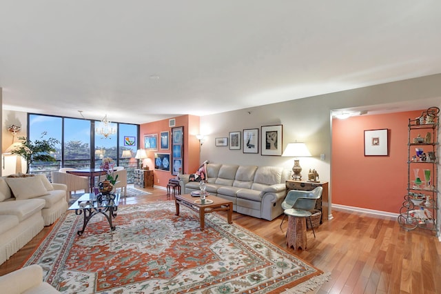 living room with expansive windows, light wood-type flooring, and an inviting chandelier