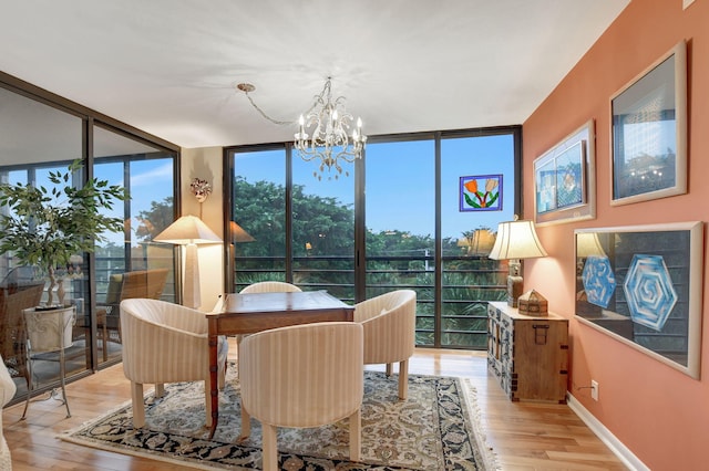 dining space featuring expansive windows, an inviting chandelier, and light wood-type flooring