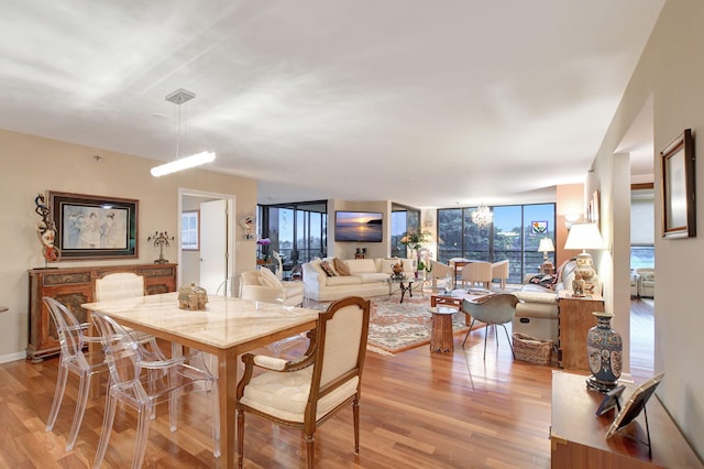 dining space featuring a wall of windows and light wood-type flooring