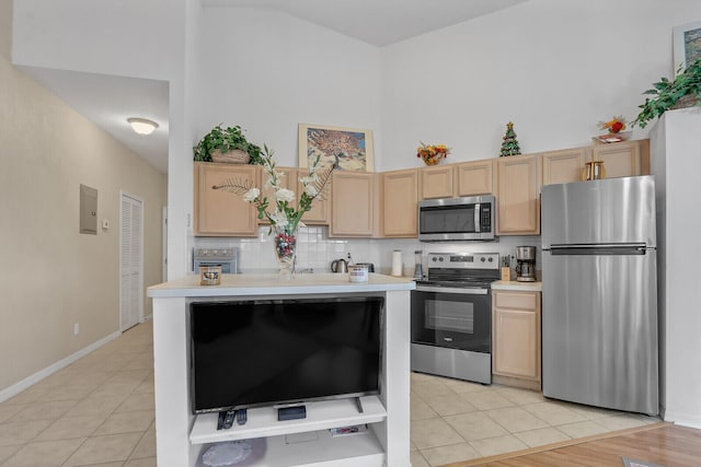 kitchen with stainless steel appliances, light brown cabinetry, and light tile patterned flooring