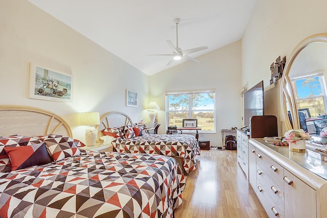 bedroom with ceiling fan, light hardwood / wood-style floors, and lofted ceiling